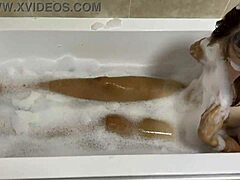 성숙한 갈색 머리카락의 여자가 목욕탕에서 노래를 부른다